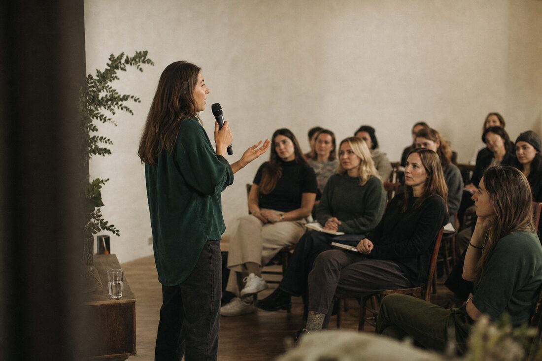 A speaker addressing a small seated audience at an industry event